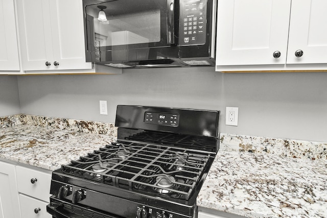 kitchen featuring black appliances, white cabinets, and light stone countertops