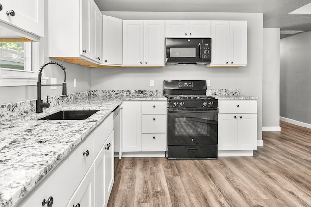 kitchen featuring white cabinets, light wood-type flooring, sink, and black appliances