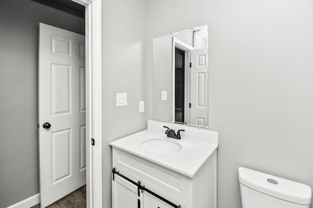 bathroom featuring vanity, toilet, and wood-type flooring