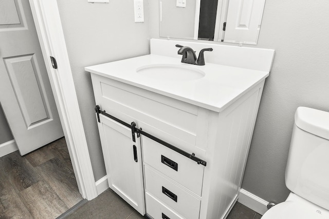 bathroom featuring hardwood / wood-style floors, vanity, and toilet