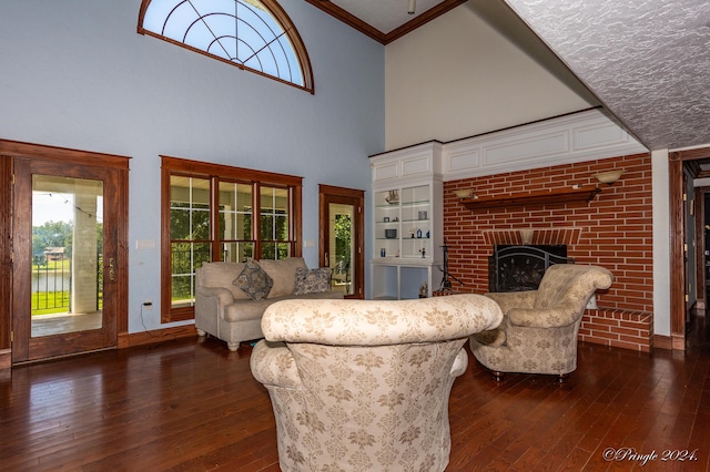 living room with a wealth of natural light, a high ceiling, a fireplace, and dark wood finished floors