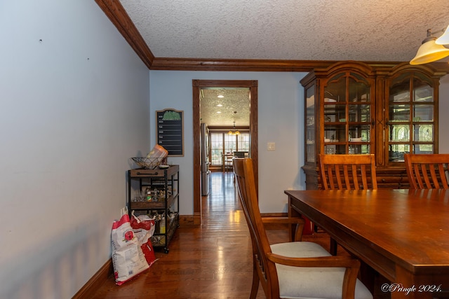 dining area featuring wood finished floors, a textured ceiling, crown molding, and baseboards