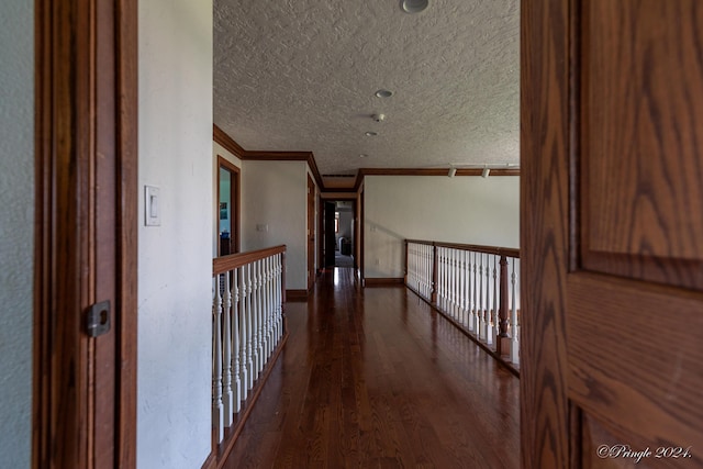 hallway featuring dark wood-style flooring, crown molding, a textured ceiling, and baseboards