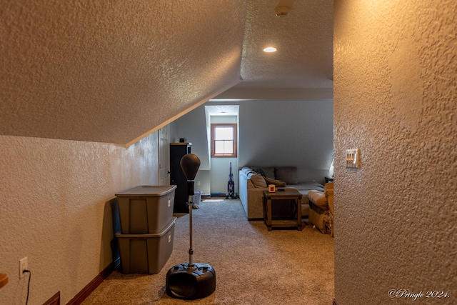 bonus room with vaulted ceiling, a textured wall, a textured ceiling, and carpet
