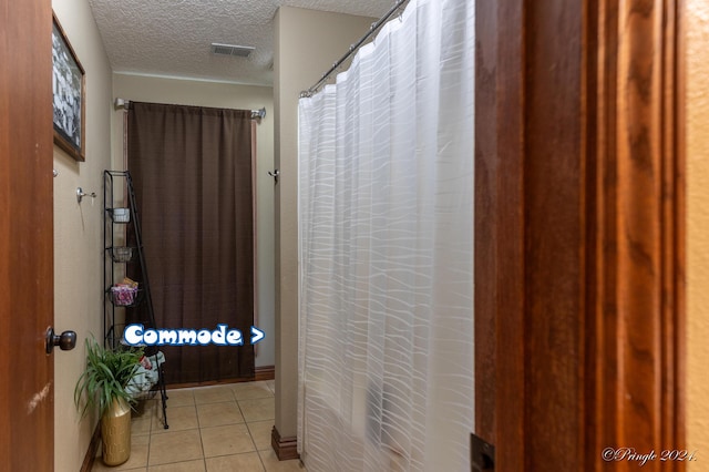 bathroom featuring tile patterned floors, curtained shower, visible vents, and a textured ceiling