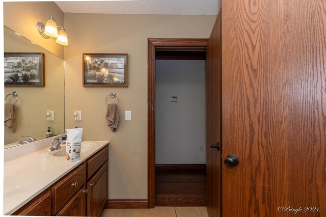 bathroom with baseboards, vanity, and tile patterned floors