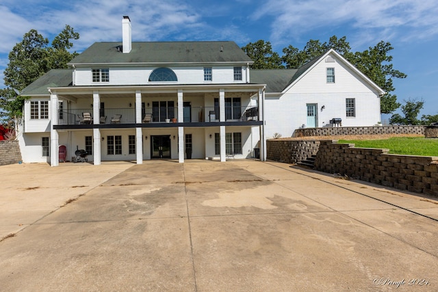 rear view of property with stairway, a chimney, french doors, and a balcony