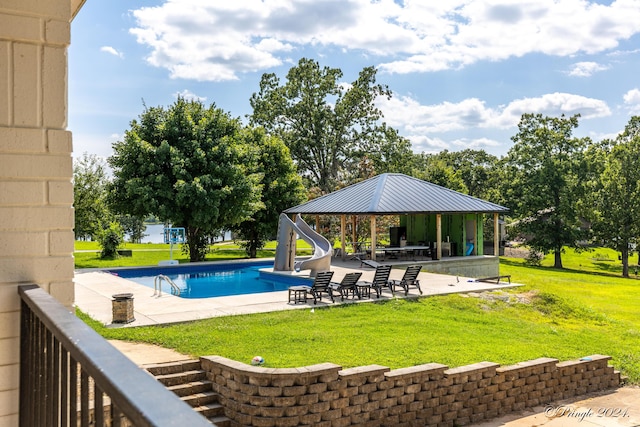 outdoor pool with a gazebo, a patio area, a water slide, and a lawn