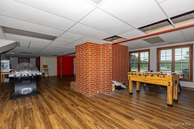 playroom featuring wood finished floors and a paneled ceiling
