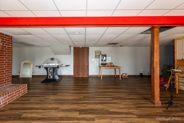 finished below grade area with a paneled ceiling, baseboards, and wood finished floors