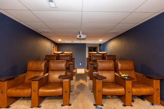 cinema room with a paneled ceiling, visible vents, and carpet flooring