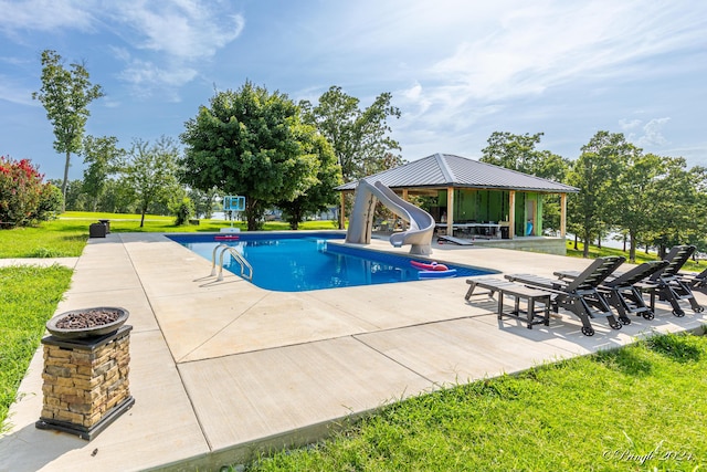 outdoor pool with a gazebo, a yard, a water slide, and a patio