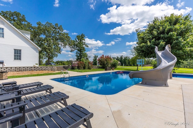 outdoor pool featuring a water slide and a patio
