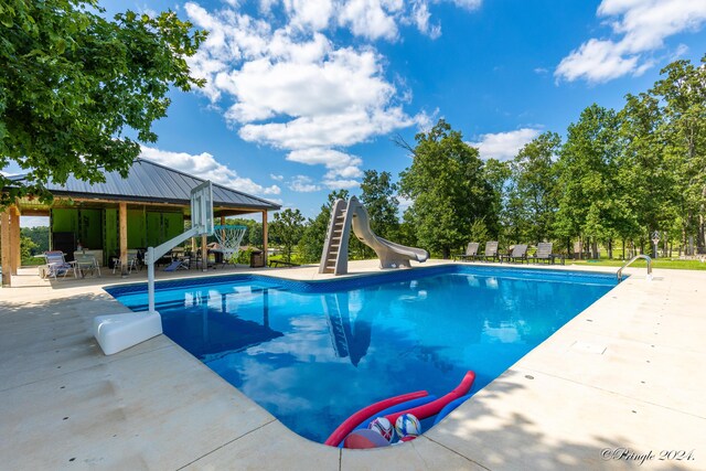 outdoor pool with a water slide, a gazebo, and a patio area