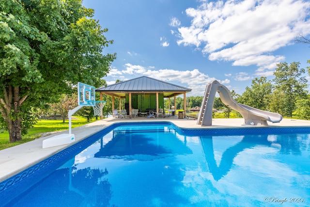 pool featuring a water slide, a gazebo, and a patio area