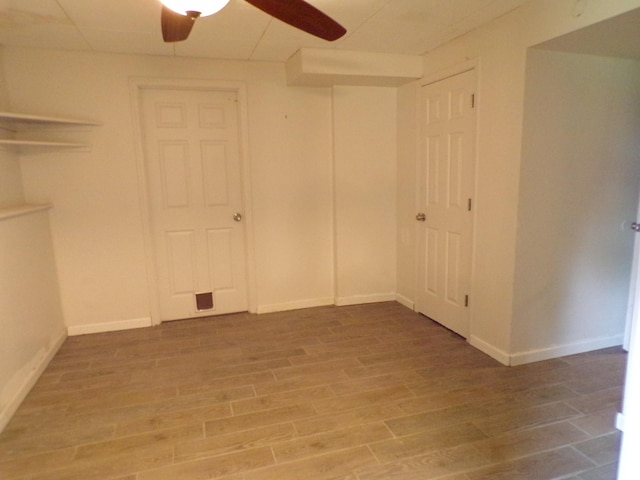 unfurnished room featuring ceiling fan, wood finished floors, and baseboards