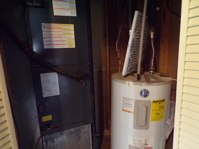 utility room featuring electric water heater and heating unit