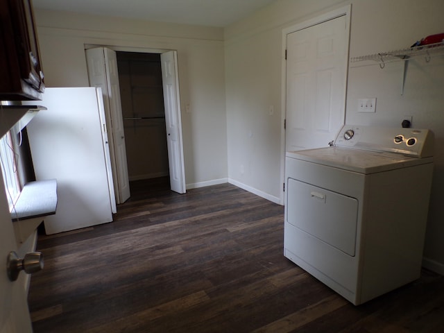 laundry area with laundry area, baseboards, washer / clothes dryer, and dark wood finished floors