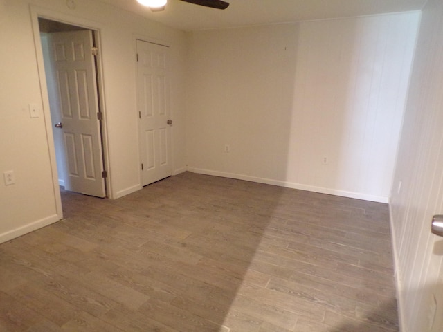 spare room with a ceiling fan, baseboards, and wood finished floors