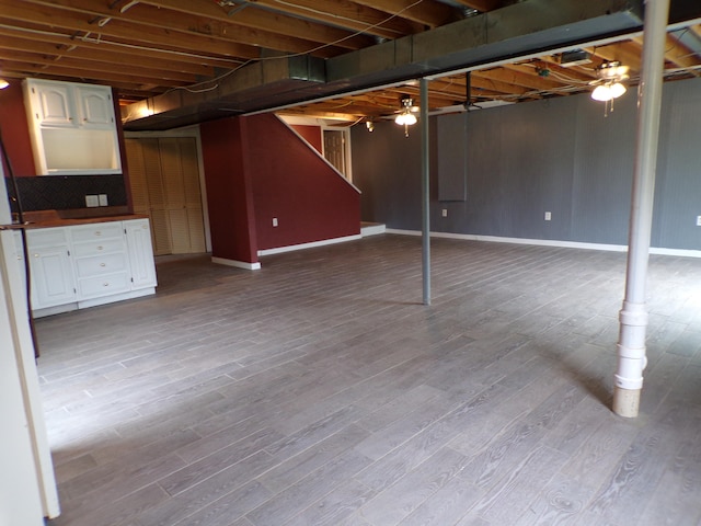 unfinished basement featuring baseboards and wood finished floors