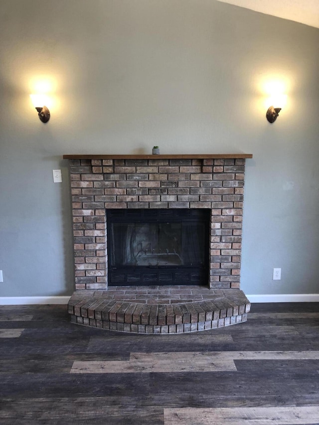 details featuring a brick fireplace, wood finished floors, and baseboards