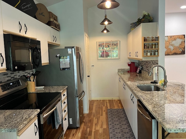 kitchen featuring stainless steel appliances, pendant lighting, backsplash, and sink