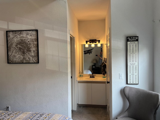 carpeted bedroom featuring sink and ensuite bathroom