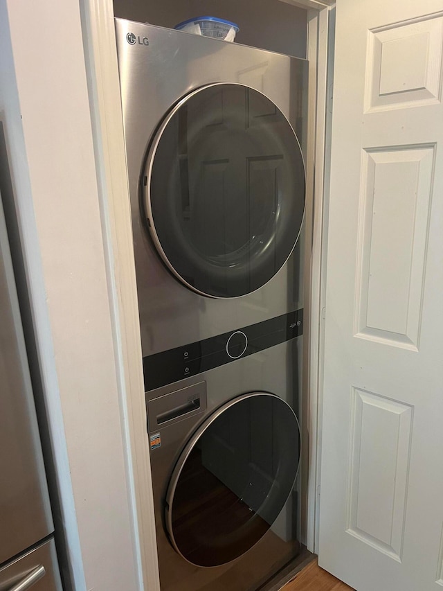 clothes washing area with stacked washer / dryer and hardwood / wood-style floors