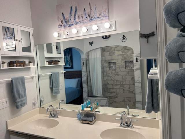 bathroom featuring a tile shower and vanity