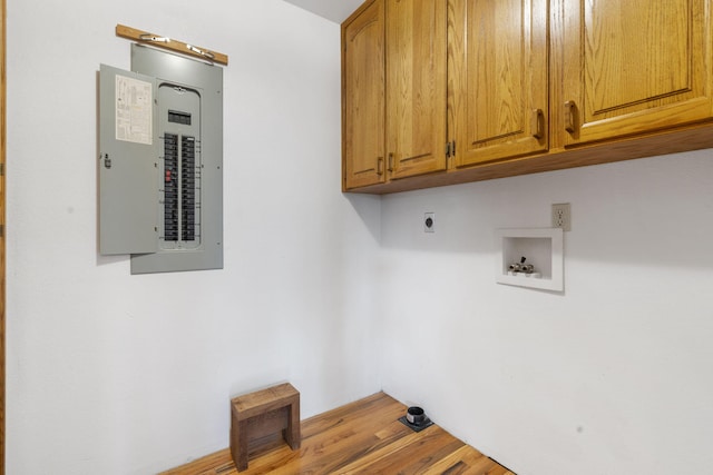 laundry area with electric panel, hookup for an electric dryer, cabinets, hookup for a washing machine, and light hardwood / wood-style floors