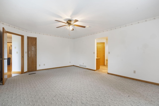 spare room featuring light carpet and ceiling fan