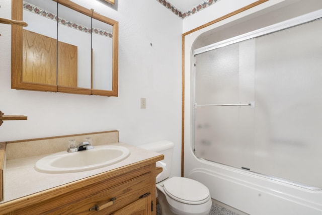 full bathroom with enclosed tub / shower combo, vanity, and toilet