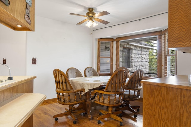 dining space featuring wood-type flooring and ceiling fan