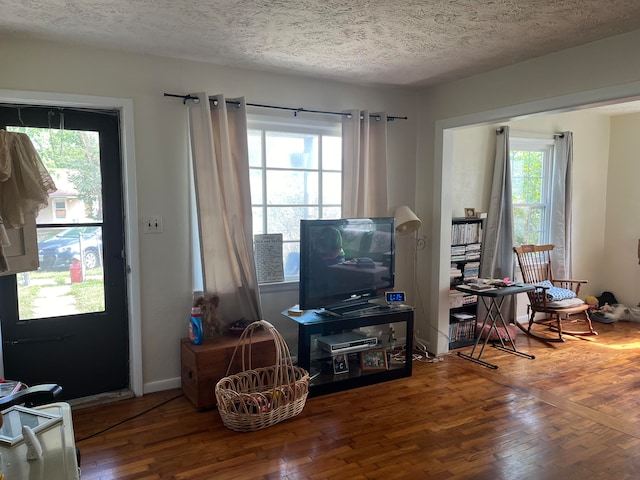 interior space featuring hardwood / wood-style flooring, a textured ceiling, and a healthy amount of sunlight