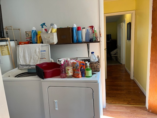 laundry area featuring hardwood / wood-style flooring, water heater, and separate washer and dryer