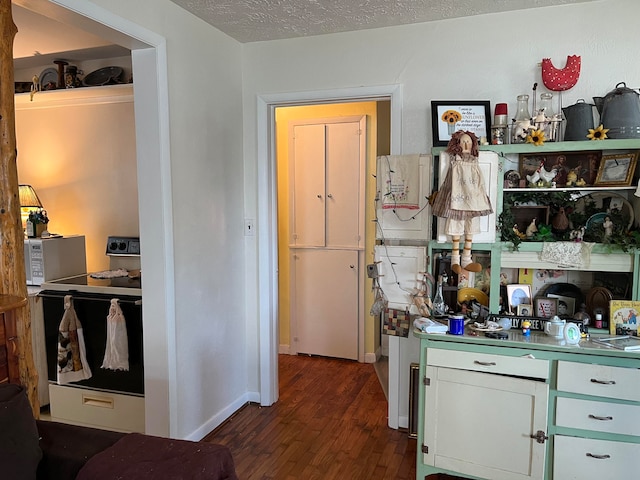 kitchen with a textured ceiling, white electric range, and dark wood-type flooring