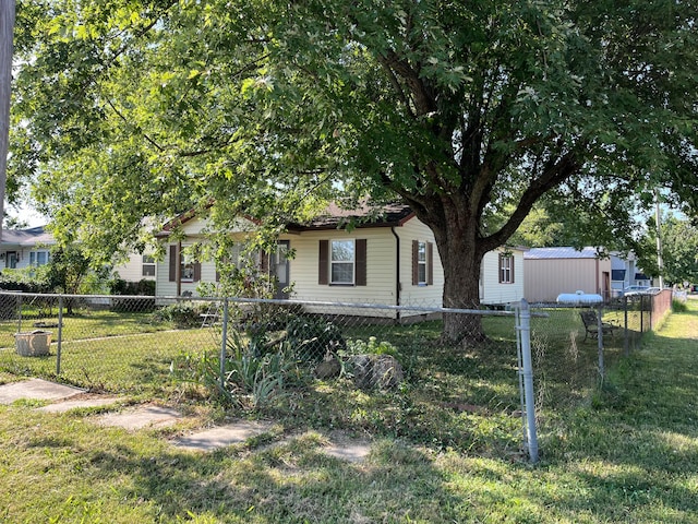 view of property hidden behind natural elements with a storage shed and a front yard