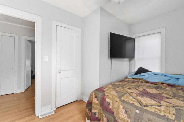 bedroom with baseboards, visible vents, and light wood-style flooring