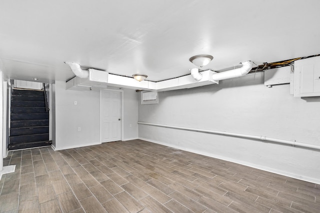 finished basement featuring stairway, baseboards, wood finished floors, and electric panel