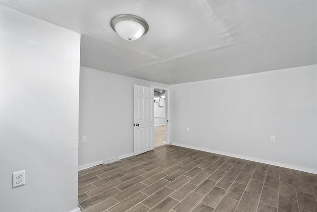 empty room with baseboards and wood finished floors