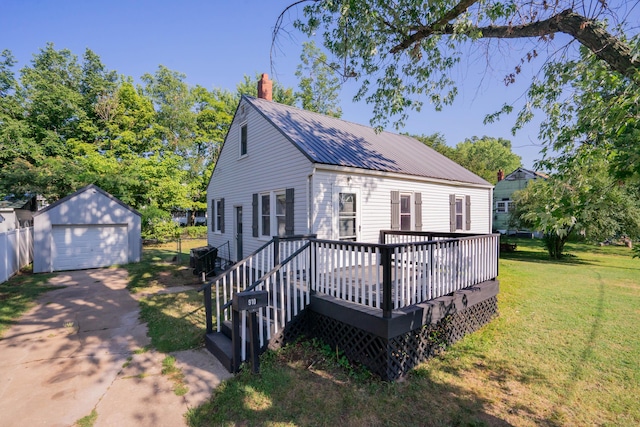 view of front of house featuring a garage, concrete driveway, metal roof, an outbuilding, and a front yard