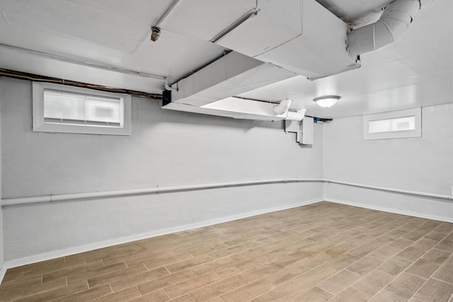 basement with baseboards and wood finished floors
