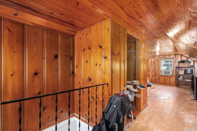 additional living space with cooling unit, wooden walls, lofted ceiling, wood ceiling, and hardwood / wood-style flooring
