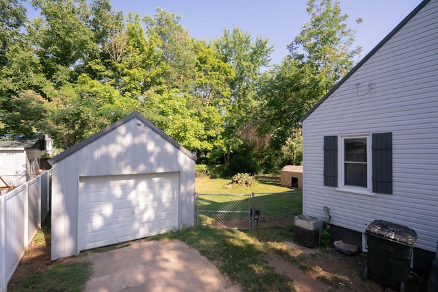 detached garage featuring fence and driveway