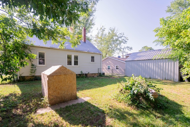 exterior space with a yard, an outbuilding, a shed, and metal roof