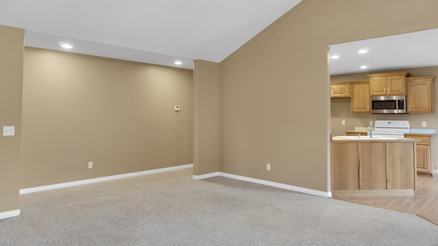 unfurnished living room featuring light colored carpet and vaulted ceiling