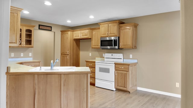 kitchen with light hardwood / wood-style floors, light brown cabinetry, sink, kitchen peninsula, and white electric range oven