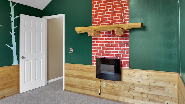 interior space featuring a fireplace, carpet flooring, and vaulted ceiling