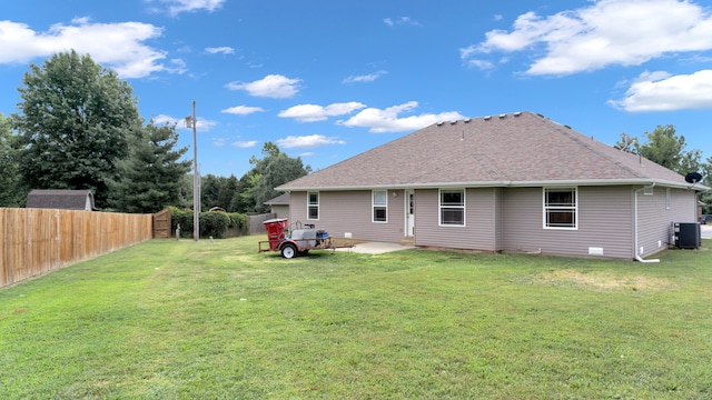 rear view of property featuring a yard and central air condition unit