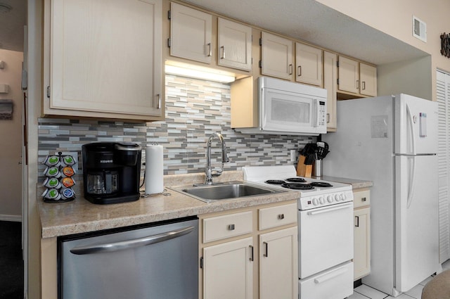 kitchen featuring sink, white appliances, and tasteful backsplash